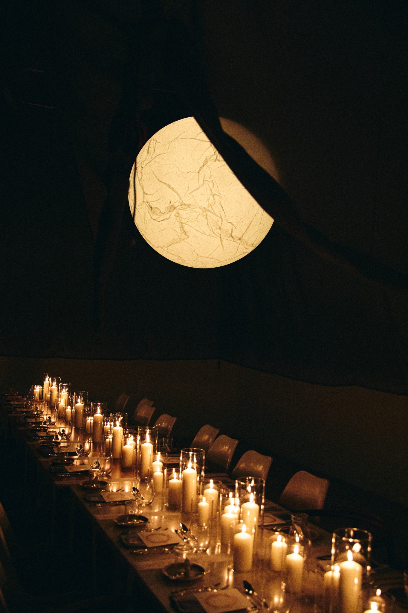Lisbon Insiders — intimate long table lit by candles beneath a sculptural lantern